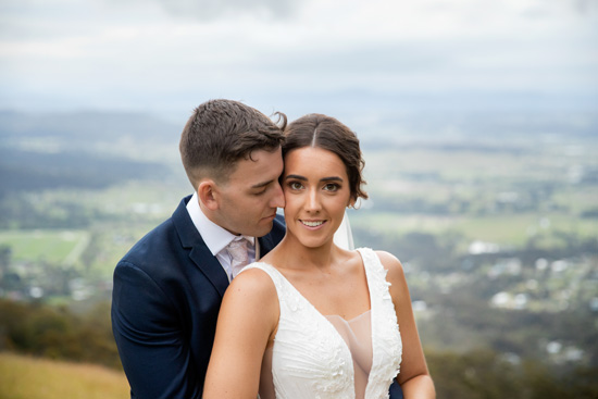 A bride and groom have their wedding photos at the lookout in Tamborine Mountain