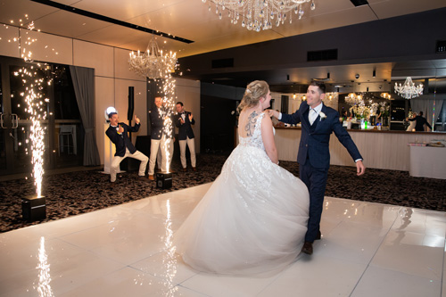 Bride and groom enter wedding reception at Sandstone Point Hotel